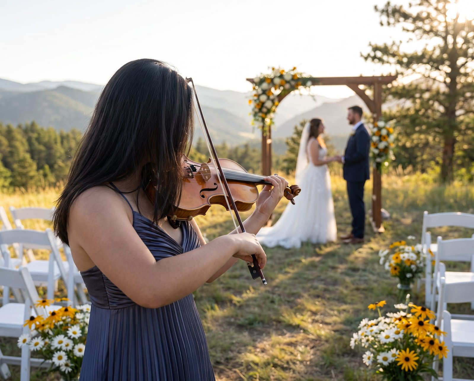 Mari Roes playing violin at an outdoor mountain wedding ceremony in Colorado